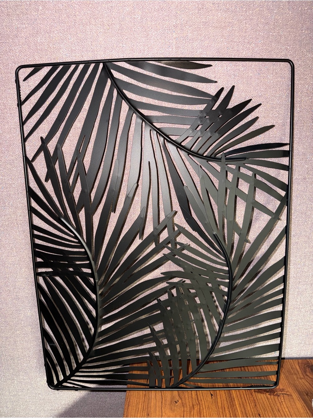 Black metal wall art with palm leaf design